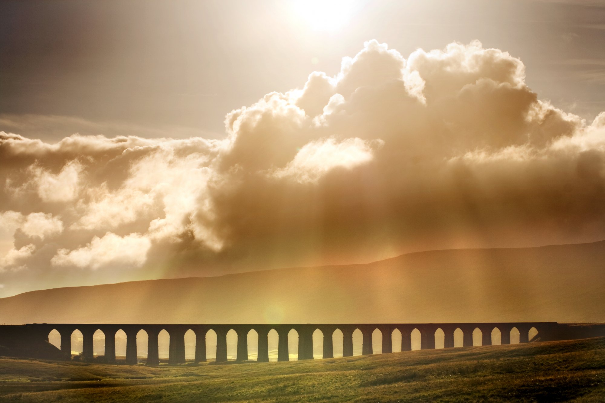 Photo of Ribblehead Viaduct and sunshine streaming through clouds - from wikimedia