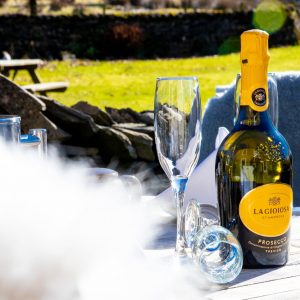 a bottle of prosecco on the table outside middle studfold farm